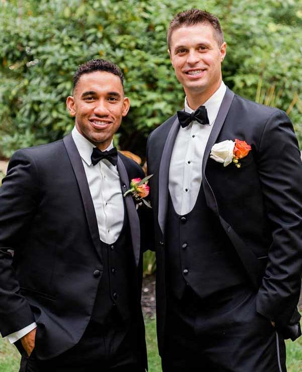 two men wearing black tuxedos and black bowties