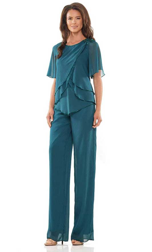 A woman wearing a teal pant suit.