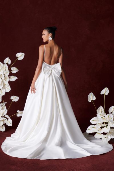 back view of a woman wearing a wedding gown with a big bow (wedding dress trends)