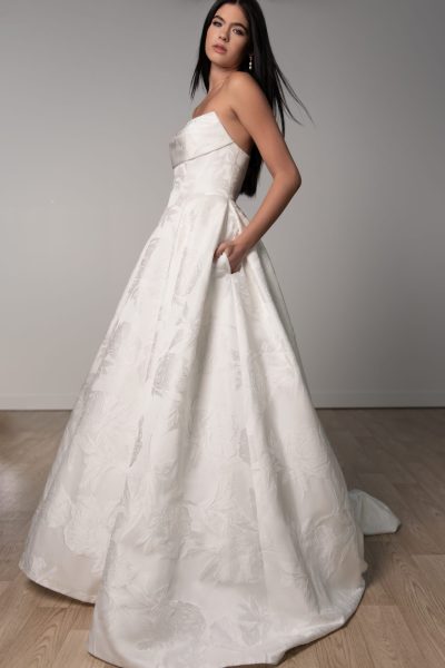 Woman with her hands in the pockets of a jacquard wedding dress (wedding dress trends)
