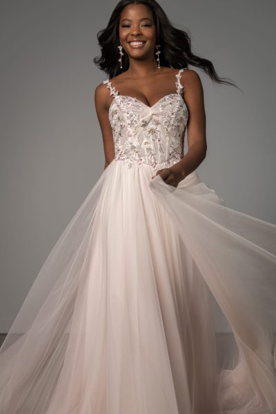 Woman twirling in a tulle blush colored wedding dress (wedding dress trends)