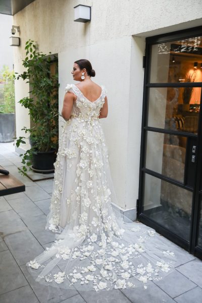 Back view of a woman wearing a wedding dress with floral appliques. (wedding dress trends).