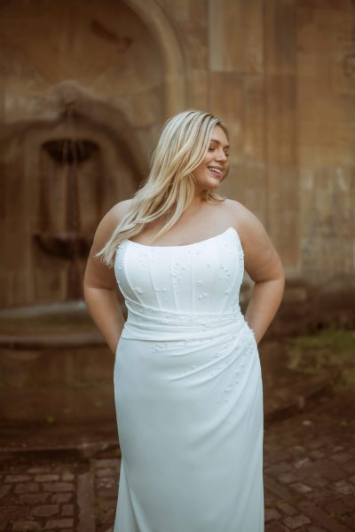 Woman wearing a simple wedding dress with cat-eye neckline (wedding dress trends)