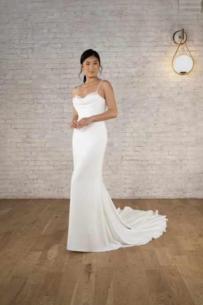 Woman wearing a sleek, simple wedding dress with a short train (wedding dress trends)